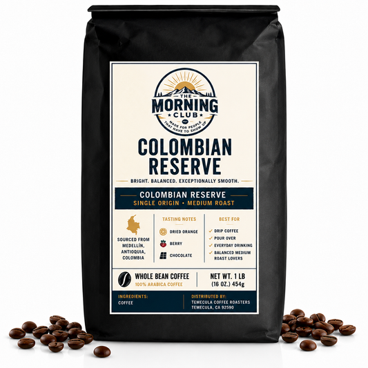 A 1 lb bag of The Morning Club Colombian Reserve single-origin medium roast coffee displayed on a white background with scattered coffee beans.